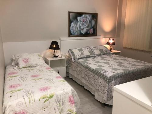 ボンビーニャスにある4 ILHAS, 2 SUITES, 2 GARAGENSのベッドルーム(ベッド2台、ランプ2つ付)
