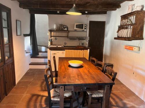 - une table en bois dans une cuisine avec un bol dans l'établissement Casa de Diego el Barbero, à Benarrabá