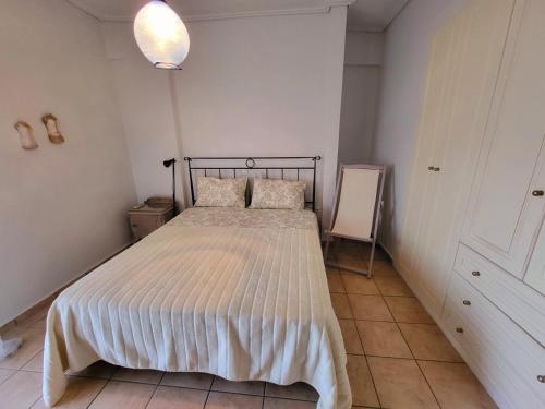 a bedroom with a bed with a white comforter at Dilion Guest Apartment in Dhílesi