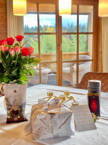 a table with a vase of flowers and a vase of roses at Ferienhaus Alpenpanorama Chalet in Mollenberg