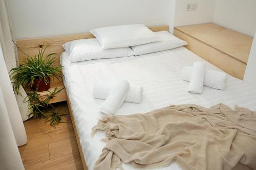 a bed with white sheets and pillows in a room at Eva's Pavaroti in Tbilisi City