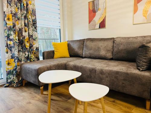 a living room with a couch and two tables at Sosnowy "3" ,Baseny Tropikalne, Ładowarka do elektryków, Faktura, Parking in Kielce