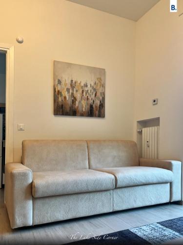 un sofá en una sala de estar con una pintura en la pared en [The LaKe-SiDe CorNer] Apartment, en Como