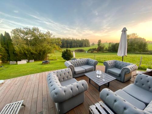 a patio with couches and a table and an umbrella at Ferienhaus Alpenpanorama Chalet in Mollenberg