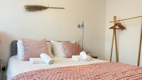 een slaapkamer met een bed met roze en witte kussens bij Le Clos Du Moulin 1 - Maison et jardin, proche Avignon, en Provence in Entraigues-sur-la-Sorgue