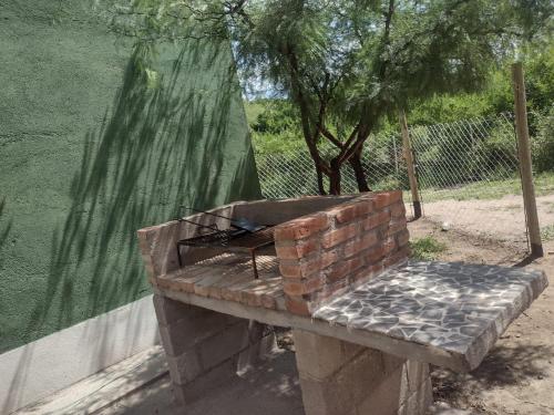 ein gemauerter Grill auf einer Bank neben einem Zaun in der Unterkunft Cabaña árbol de Nonsacate in San Marcos Sierras