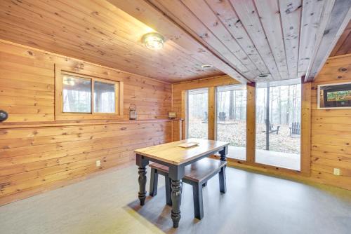 a dining room with wooden walls and a wooden table at Cozy Wisconsin Cabin with Deck, Kayaks and Lake Views! in Hayward