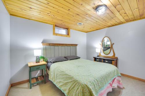 a bedroom with a bed and a mirror at Cozy Wisconsin Cabin with Deck, Kayaks and Lake Views! in Hayward