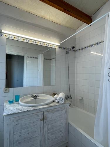 a bathroom with a sink and a tub and a mirror at Villa Pont d'En Gil in Cala en Blanes