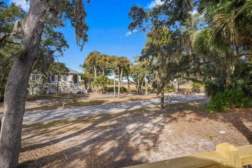 an open yard with trees and a house at 4bd/3ba - Renovated Center Island Home & Garage Apt - Amenity Cards Avail - Pets ok in Fripp Island