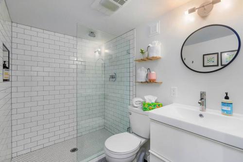 a bathroom with a toilet and a sink and a mirror at Mid-Century Vibes Nest in Seattle