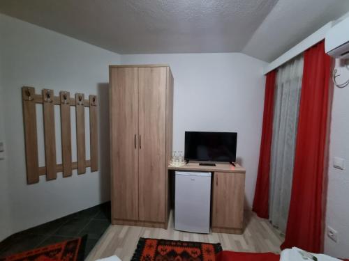 een kamer met een bureau, een televisie en een kast bij Fantastik Ayaz Apartments in Ohrid