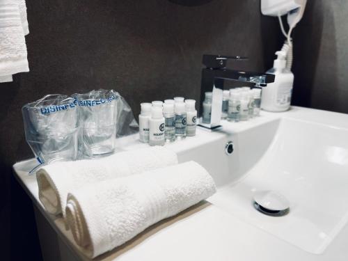 a bathroom sink with toiletries and towels on it at MOZAIK APARTMENTS & SPA - Modern 4-Star Apartments with Exclusive Private SPA WELLNESS in the City Center - SAUNA, JACUZZI, TURKISH BATH - FREE PARKING, Wi-FI - Rooms & Apartments Cuprija in Ćuprija