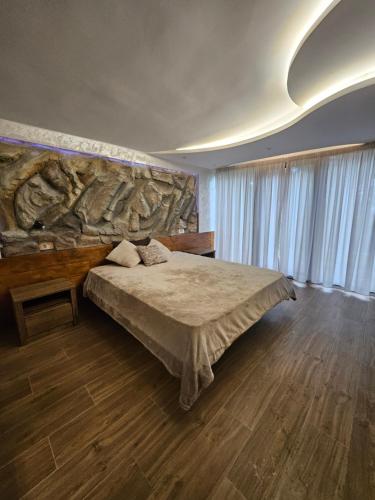 a bedroom with a bed and a stone wall at Apartman Jovanic in Divčibare