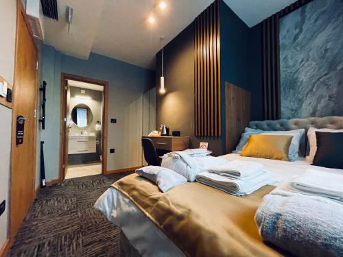 a bedroom with a large bed with towels on it at MOZAIK APARTMENTS & SPA - Modern 4-Star Apartments with Exclusive Private SPA WELLNESS in the City Center - SAUNA, JACUZZI, TURKISH BATH - FREE PARKING, Wi-FI - Rooms & Apartments Cuprija in Ćuprija