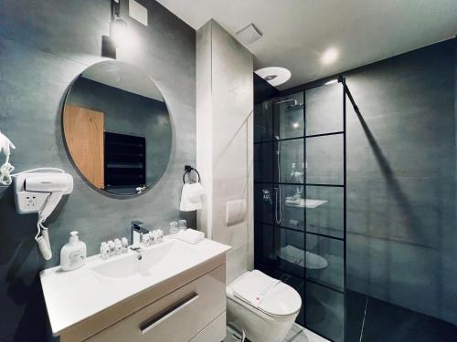 a bathroom with a toilet and a sink and a mirror at MOZAIK APARTMENTS & SPA - Modern 4-Star Apartments with Exclusive Private SPA WELLNESS in the City Center - SAUNA, JACUZZI, TURKISH BATH - FREE PARKING, Wi-FI - Rooms & Apartments Cuprija in Ćuprija