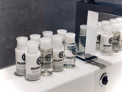 a group of bottles on a bathroom sink at MOZAIK APARTMENTS & SPA - Modern 4-Star Apartments with Exclusive Private SPA WELLNESS in the City Center - SAUNA, JACUZZI, TURKISH BATH - FREE PARKING, Wi-FI - Rooms & Apartments Cuprija in Ćuprija