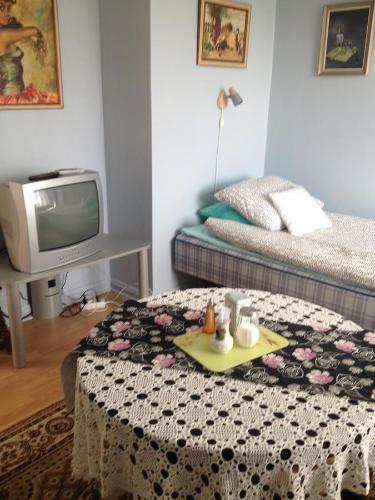 Habitación con cama, TV y mesa. en Vivans Bed and Self catering, en Kristianstad