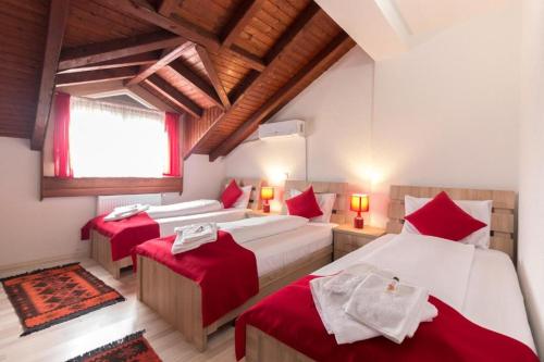 een slaapkamer met 3 bedden en rode kussens bij Fantastik Ayaz Apartments in Ohrid