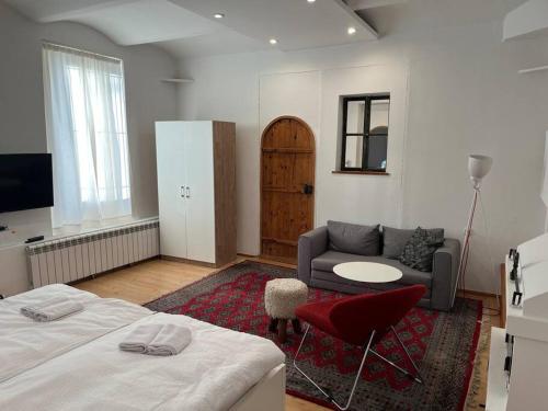 een slaapkamer met een bed, een bank en een tafel bij Srce Sarajeva in Sarajevo