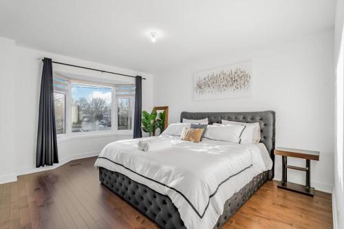 Un dormitorio con una cama grande y una ventana en Spacious Home! 5 King Beds, 1 Queen, Modern Luxury, Free Parking, en Pointe-Claire