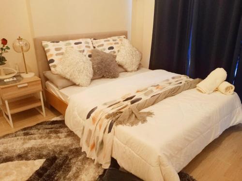 a bed with two pillows on it in a bedroom at Unit 3J Signature Suites, Lafayette Megaworld in Iloilo City