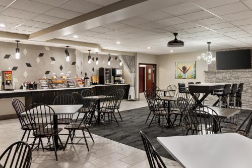 a restaurant with tables and chairs and a counter at La Quinta Inn & Suites by Wyndham Lake George in Lake George