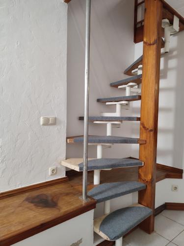 a staircase in a room with wooden stairs at Wohnen an der Stadtmauer in Neuruppin
