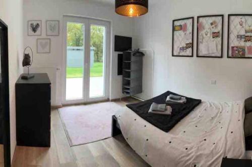 a bedroom with a bed and a large window at Le rez de chaussée de chez Jade 