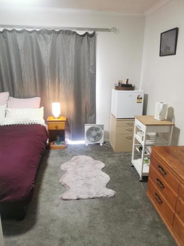 a bedroom with a bed and a desk and a window at Cozy Double Room - WIFI in Hamilton