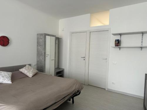 1 dormitorio con 1 cama y paredes blancas en Monolocale Centro storico, en Pordenone