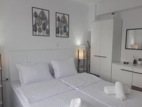 una camera da letto bianca con un letto con lenzuola e cuscini bianchi di Tahtidis 3 a Xánthi