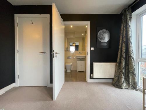 a bathroom with black walls and a white door at Family & Business Stays In RG2 - Sleeps Up to 12! in Reading