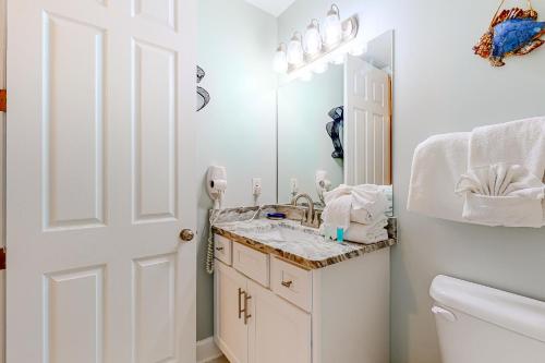a white bathroom with a sink and a mirror at Regency Isle 611 in Orange Beach