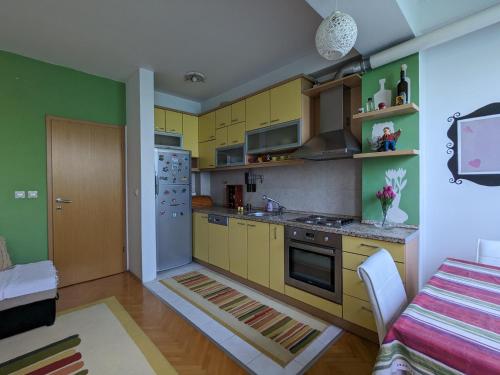 uma cozinha com armários amarelos e um frigorífico branco em Artistica Apartment Skopje, 2 bdr em Skopje