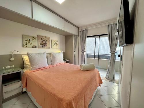 1 dormitorio con cama y ventana grande en Cobertura Baixa Coral Gables, en Balneário Camboriú