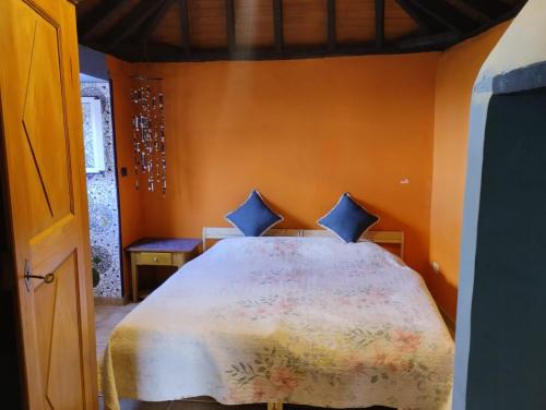- une chambre avec un grand lit aux murs orange dans l'établissement Casa Mosaico, sunset and garden, à Los Llanos de Aridane