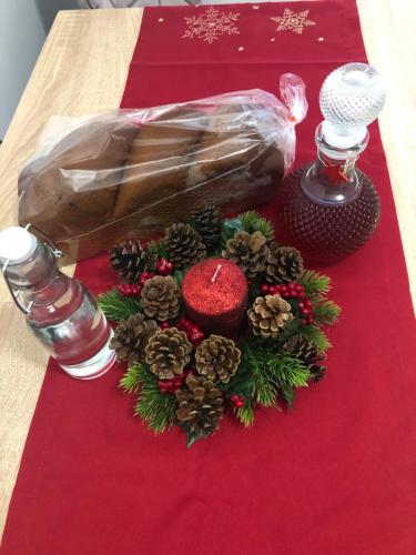 a table topped with a christmas wreath and a glass bottle at Apartament CHIC in Vatra Dornei