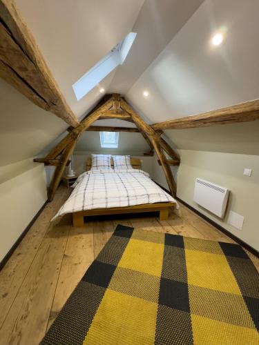 a attic bedroom with a bed and a vaulted ceiling at Magnifique maison entière, meublée tout confort et son jardin clos privé in Villeblevin