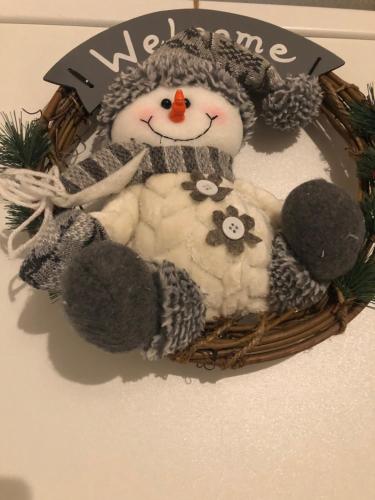 a teddy bear in a basket with a snowman at Apartament CHIC in Vatra Dornei