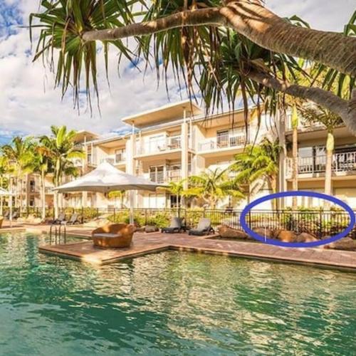 a swimming pool in front of a building at Lagoon Pool Access Salt Resort & Spa 1br (Peppers) in Kingscliff