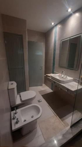 a bathroom with a toilet and a sink and a mirror at La Manquel - Casa y Yungas in Yerba Buena