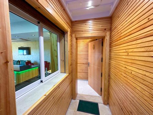 a sauna with wooden walls and a large window at Luxurious Scandinavian-style with swimming pool and play area - Fast wifi in Oued Laou