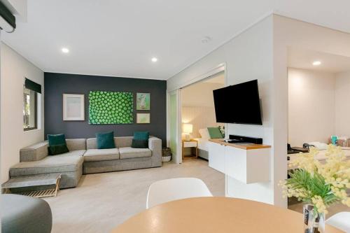 a living room with a couch and a tv at Lagoon Pool Access Salt Resort & Spa 1br (Peppers) in Kingscliff
