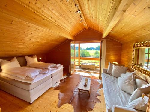 a large room with a bed and a couch at Ferienhaus Alpenpanorama Chalet in Mollenberg