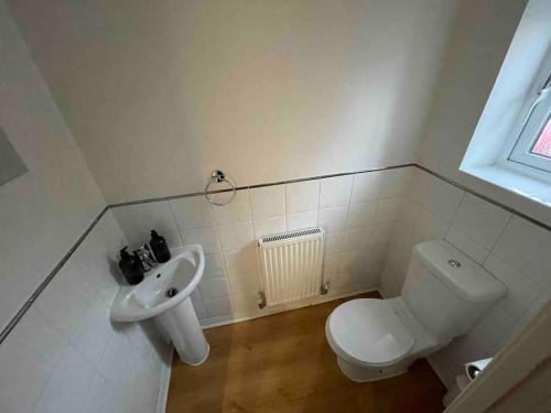 a bathroom with a toilet and a sink at Chineham Retreat - Spacious Home For Leisure & Business Stays - Sleeps 8 in Sherborne Saint John