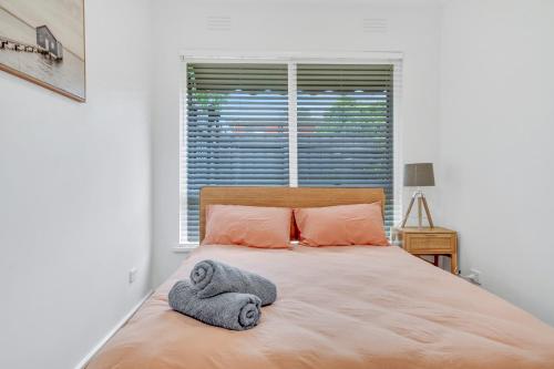 1 dormitorio con 1 cama con toallas en Cheltenham Delight - Renovated Two Bedroom Unit, en Cheltenham