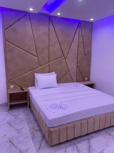 a bedroom with a large bed with a large headboard at Hôtel victoria in Brazzaville