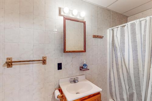 een badkamer met een wastafel, een spiegel en een douche bij Seafoam Dreams in York