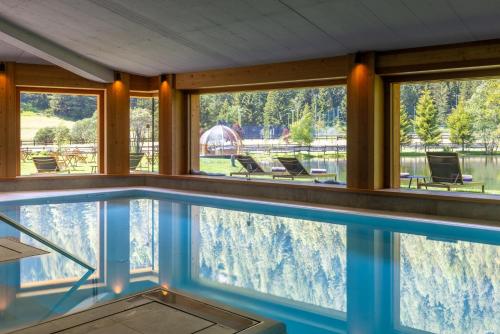 a swimming pool in a house with a view at Au Charmant Petit Lac - Ecohotel Parc & Spa in Champoluc